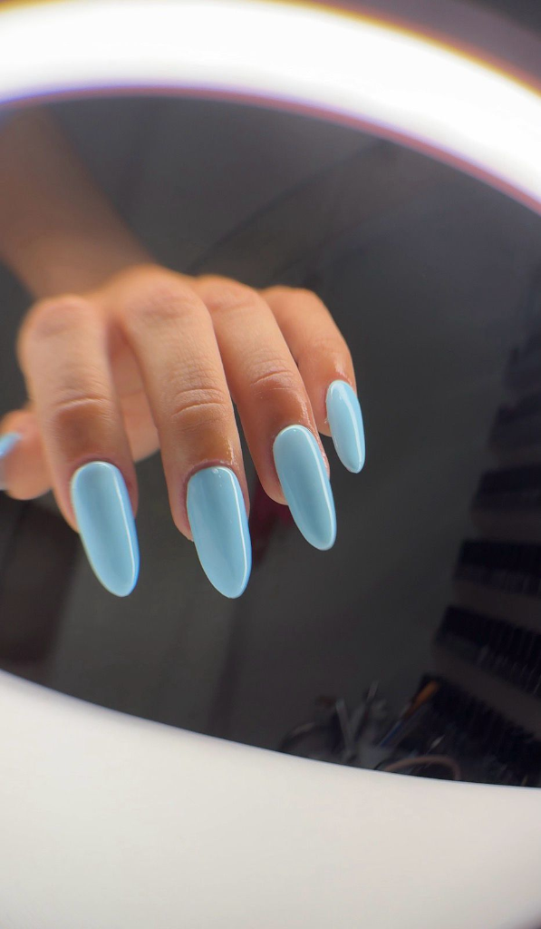 Uñas almendradas con esmalte azul cielo brillante